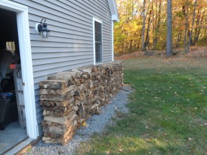 View on the side of our house with growing wood pile